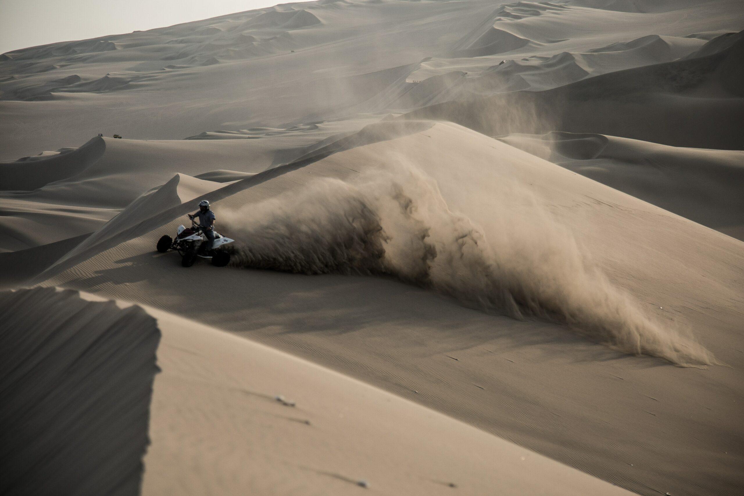 Une personne pratiquant du quad dans le désert. Une activité très amusante pour un voyage entre amis.